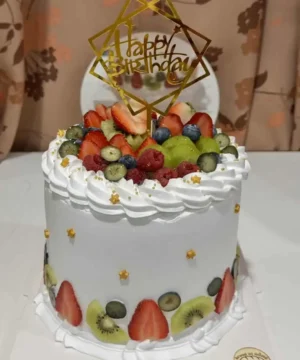 เค้กวันเกิดผลไม้สดพร้อมคำว่า Happy Birthday บนยอดเค้ก สร้างความสุขในโอกาสพิเศษ.