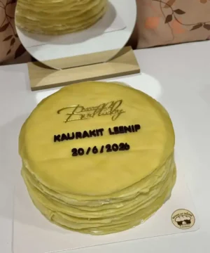 เค้กวันเกิดสีเหลืองสดใสพร้อมข้อความและวันที่ในงานเฉลิมฉลอง.