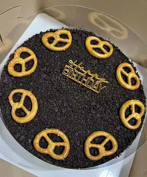 อัลตราเบลนด์โอรีโอ้ชีสพาย เนื้อเนียนและรสชาติพิเศษ พร้อมตกแต่งด้วย pretzel รูปหัวใจบนเค้กวันเกิดที่น่ารับประทาน.