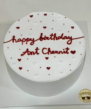 เค้กวันเกิดสีขาวตกแต่งด้วยหัวใจสีแดงและขาว พร้อมข้อความ 'happy birthday Ant Chanut' สำหรับโอกาสพิเศษ.