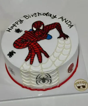 เค้กวันเกิดสไปเดอร์แมนพร้อมข้อความ Happy Birthday ANDA และลายแมงมุมบนเค้ก.