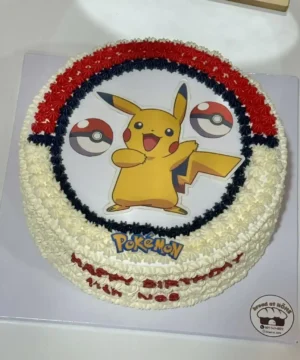 เค้กโปเกม่อนสีสันสดใสพร้อมภาพ Pikachu และลูกบอลโปเกม่อนบนหน้าเค้ก เหมาะสำหรับงานวันเกิดเด็กและแฟนพันธุ์แท้โปเกมอนทุกวัย.