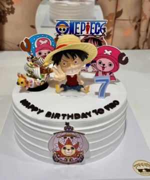 เค้กวันเกิดลายการ์ตูนวันพีชพร้อมตัวละครและสัญลักษณ์จากอนิเมะ.