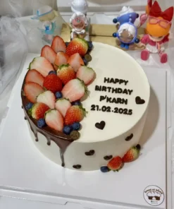 กล่องเค้กวันเกิดพร้อมผลไม้สดในบรรยากาศอบอุ่นและน่ารัก พร้อมข้อความสุขสันต์วันเกิดและวันที่ 21.02.2025 สำหรับโอกาสฉลองที่บ้านในธีม Bread at HÖME.