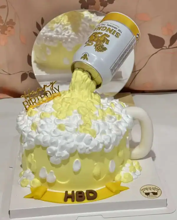 เค้กแก้วเบียร์ไม่มีแอลกอฮอล์ ตกแต่งด้วยครีมสดวนิลาและของตกแต่งสีเหลือง.