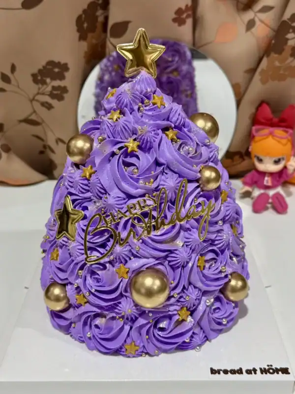 เค้กต้นคริสต์มาสสีม่วงประดับดาวทองและลูกบอลทอง สวยงามสำหรับฉลองเทศกาลคริสต์มาสและวันเกิดในช่วงฤดูหนาว.