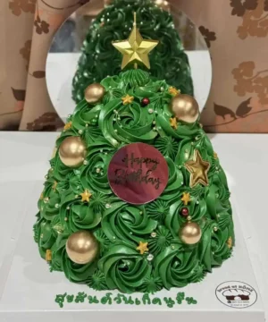 เค้กต้นคริสต์มาสสีเขียวประดับด้วยลูกบอลทองและดาวทอง พร้อมข้อความสุขสันต์วันคริสต์มาส.