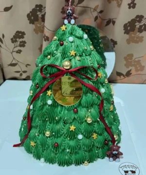 เค้กต้นคริสต์มาสตกแต่งด้วยไอเท็มคริสต์มาสสีเขียวสดใส พร้อมลูกบอลและริบบิ้นแดง เหมาะสำหรับงานเฉลิมฉลองในช่วงเทศกาลคริสต์มาส.