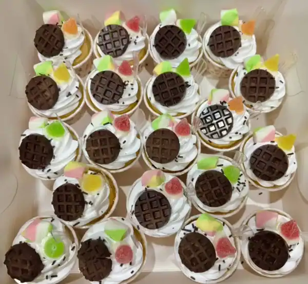 หวานกล่องของคัพเค้กที่ตกแต่งด้วยช็อกโกแลตและลูกกวาดสีสันสดใส พร้อมเนื้อสัมผัสนุ่มนวลและรสชาติหวานอร่อย เติมเต็มความสุขในทุกคำ.