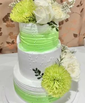 คลังภาพเค้กแต่งด้วยดอกไม้สีขาวและเขียวสดใส เหมาะสำหรับงานเลี้ยง ฉลอง โชว์ความสวยงามและความประณีตของการทำเค้กอย่างยอดเยี่ยม.