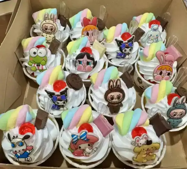 อาหารหวานคัพเค้กลายการ์ตูนสุดน่ารัก พร้อมวิปครีมและตกแต่งด้วยลูกกวาดสีสันสดใส เหมาะสำหรับงานปาร์ตี้และของขวัญสุดพิเศษ.