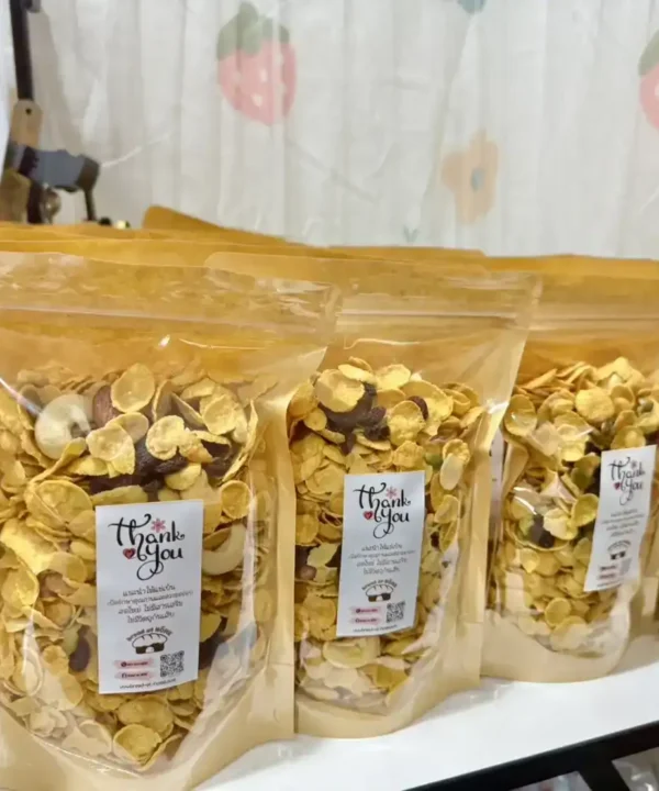 ขนมข้าวโอ๊ตอบกรอบบรรจุในถุงพลาสติก จัดเรียงอย่างเป็นระเบียบบนโต๊ะในร้านเบรดแอทโฮม สินค้าขนมปังและขนมอบที่มีคุณภาพและรสชาติอร่อย สำหรับผู้ชื่นชอบอาหารทำเองที่บ้านในสไตล์โฮมเมด.