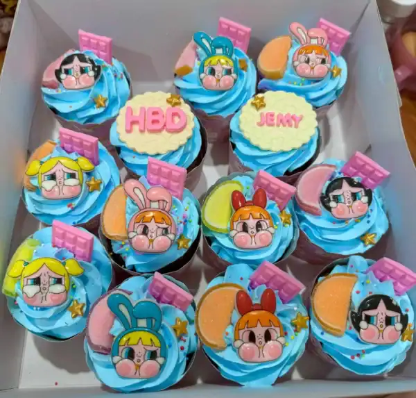 หลานเค้กน่ารักแต่งด้วยคิทแคทและการ์ตูนเจ้าหญิงสุดน่ารักในโทนสีฟ้า เติมลายละเอียดด้วยโมบายค์และทองคำ สำหรับเฉลิมฉลองวันเกิดและความสุขครอบครัว.