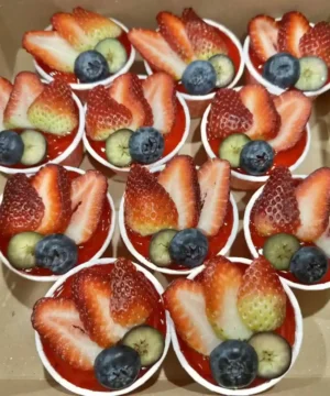 สตรอว์เบอร์รี่และบลูเบอร์รี่ในถ้วยครีม สดชื่นและอร่อย เหมาะสำหรับของหวานและงานฉลองในบ้าน เพิ่มความหวานจากผลไม้สดในทุกโอกาส.