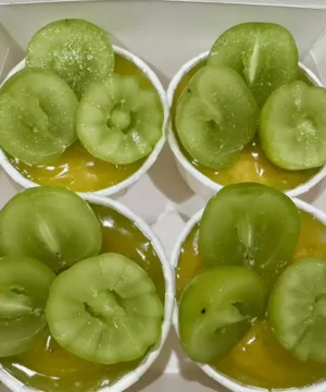 ลูกเกดเขียวในถ้วยขนมหวาน จานเดียวกับวุ้นมะพร้าว กล้วยหอมและลูกเกดเขียวสด รสหวานอร่อย ในบรรยากาศอบอุ่นของบ้านที่ทำขนมเอง.