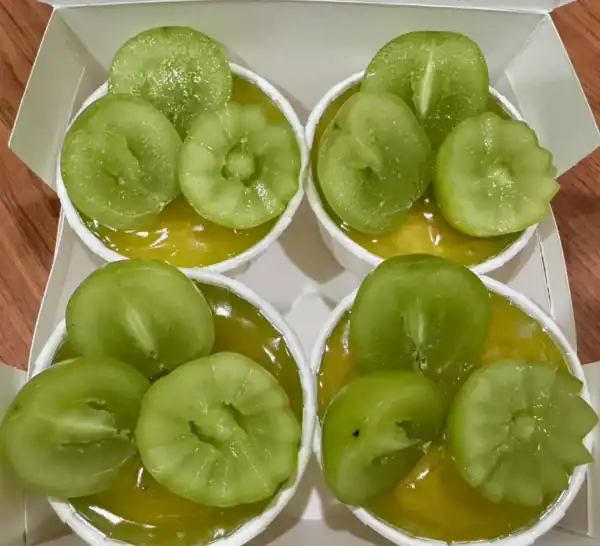 ลูกเกดเขียวในถ้วยขนมหวาน จานเดียวกับวุ้นมะพร้าว กล้วยหอมและลูกเกดเขียวสด รสหวานอร่อย ในบรรยากาศอบอุ่นของบ้านที่ทำขนมเอง.