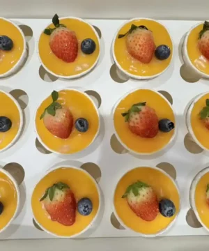 กล่องขนมหวานผลไม้สด สตรอเบอร์รี่ บลูเบอร์รี่ และเนื้อผลไม้สีส้มสด สวยงาม ให้กลิ่นหอมและรสชาติหวานอร่อย เหมาะสำหรับขนมหวานในร้าน bread at home.