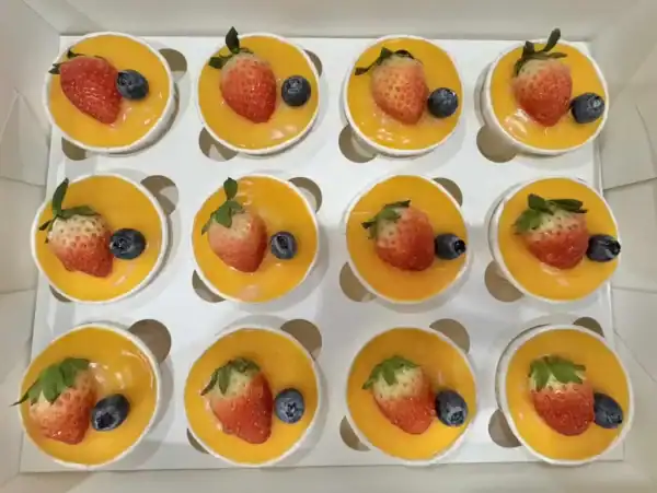 กล่องขนมหวานผลไม้สด สตรอเบอร์รี่ บลูเบอร์รี่ และเนื้อผลไม้สีส้มสด สวยงาม ให้กลิ่นหอมและรสชาติหวานอร่อย เหมาะสำหรับขนมหวานในร้าน bread at home.