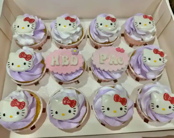 คัพเค้กคิตตี้ Hello Kitty สีชมพูและม่วง พร้อมตกแต่งด้วยครีมและลายคิตตี้น่ารัก เหมาะสำหรับงานปาร์ตี้และของขวัญสุดพิเศษ.