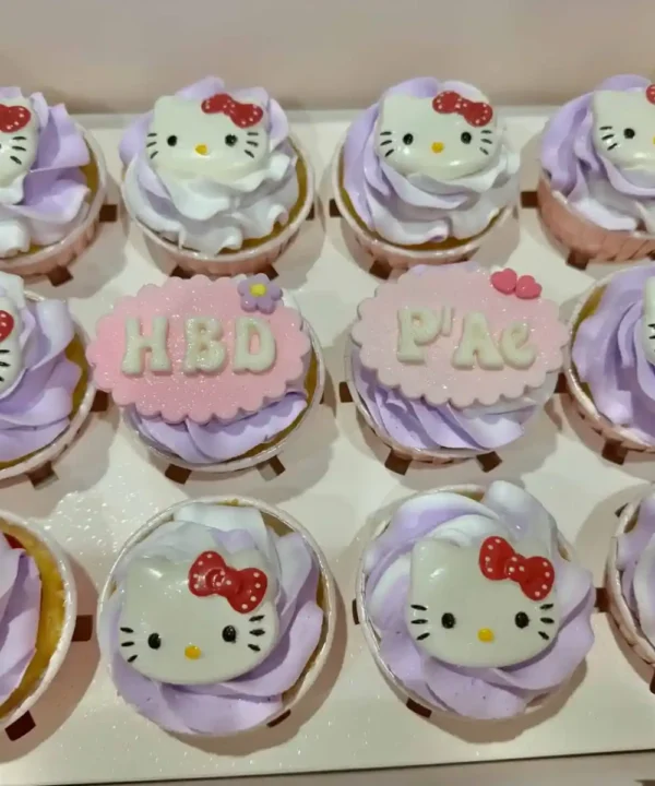 คัพเค้กคิตตี้ Hello Kitty สีชมพูและม่วง พร้อมตกแต่งด้วยครีมและลายคิตตี้น่ารัก เหมาะสำหรับงานปาร์ตี้และของขวัญสุดพิเศษ.
