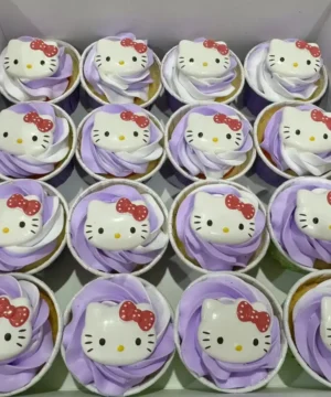 คัพเค้กคิตตี้ Hello Kitty สีขาวและม่วง พร้อมตกแต่งด้วยหน้าคิตตี้และโบว์แดง.