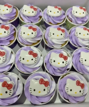 คัพเค้กคิตตี้สีขาวและแดงบนพื้นหลังสีม่วงอ่อน สวยงามและน่ารับประทาน เหมาะสำหรับงานปาร์ตี้และของขวัญพิเศษในโอกาสต่าง ๆ.