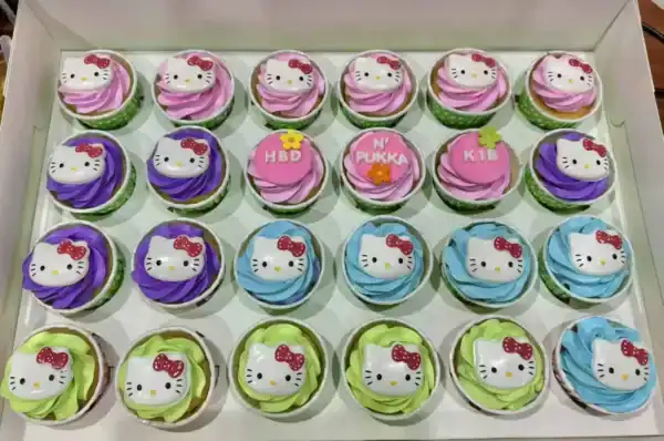 คัพเค้ก Hello Kitty สีสันสดใสในกล่อง พร้อมตกแต่งลาย Hello Kitty และข้อความวันเกิด.