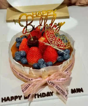 เค้กผลไม้สดและช็อกโกแลตตกแต่งด้วยผลเบอร์รี่และคำว่า Happy Birthday สำหรับโอกาสพิเศษ.