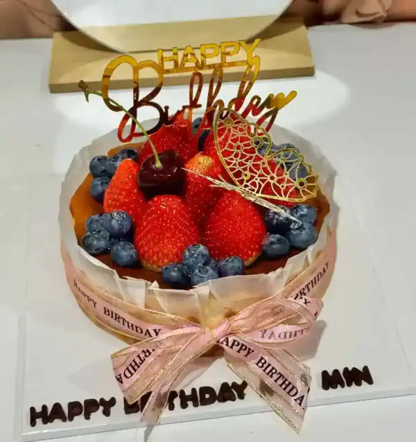 เค้กผลไม้สดและช็อกโกแลตตกแต่งด้วยผลเบอร์รี่และคำว่า Happy Birthday สำหรับโอกาสพิเศษ.