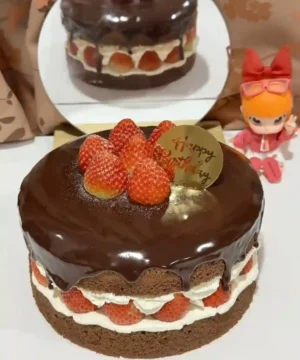 เค้กช็อกโกแลตสตรอเบอร์รี่สุดหรู พร้อมชั้นครีมและผลไม้สด ราดด้วยซอสช็อกโกแลตเข้มข้น เหมาะสำหรับงานพิเศษและคนรักของหวาน.
