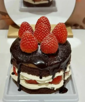 เค้กช็อกโกแลตสตรอว์เบอร์รี่เนื้อเนียน ราดด้วยซอสช็อกโกแลตเข้มข้น ตกแต่งด้วยสตรอว์เบอร์รี่สดบนยอด เค้กหวานละมุนรสชาติลงตัว.