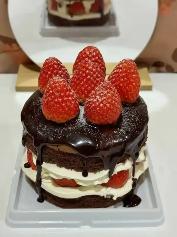 เค้กช็อกโกแลตสตรอว์เบอร์รี่เนื้อเนียน ราดด้วยซอสช็อกโกแลตเข้มข้น ตกแต่งด้วยสตรอว์เบอร์รี่สดบนยอด เค้กหวานละมุนรสชาติลงตัว.