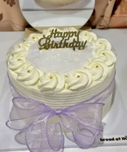 เค้กมะพร้าวอ่อนครีมสดเนื้อเนียนหวานหอม พร้อมตกแต่งด้วยครีมและคำว่า Happy Birthday บนยอดเค้ก.