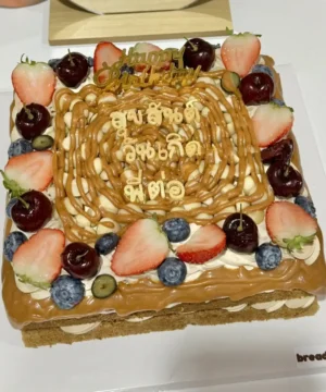 เค้กกาแฟคาราเมลแมคคาเดเมียสุดหรู พร้อมผลไม้สดและตกแต่งสวยงาม เหมาะสำหรับโอกาสพิเศษและความสุขในทุกคำ.