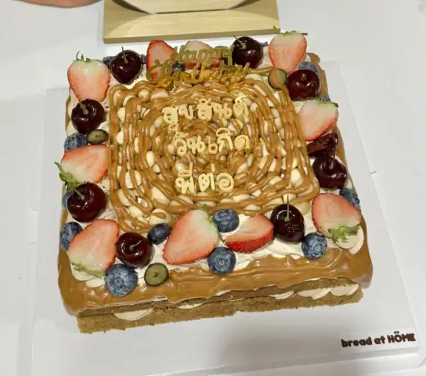 เค้กกาแฟคาราเมลแมคคาเดเมียสุดหรู พร้อมผลไม้สดและตกแต่งสวยงาม เหมาะสำหรับโอกาสพิเศษและความสุขในทุกคำ.