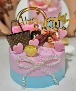 เค้กวันเกิดสีชมพูพร้อมของตกแต่งทองและภาพผสมผสานของคนและแบรนด์เนม เพิ่มความสนุกสนานและหรูหราในงานเลี้ยงสนุกสนานและแฟชั่นสุดหรู.