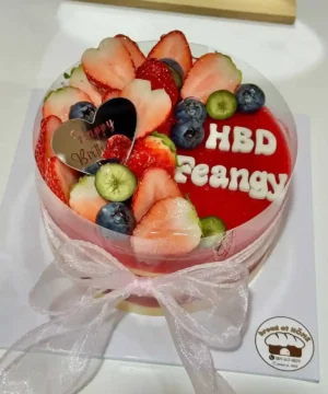 อาหารหวานเค้กผลไม้สด สตรอเบอรี่ บลูเบอรี่ และกีวี ตกแต่งอย่างสวยงามบนเค้กเนียนนุ่ม พร้อมคำอวยพรวันเกิด.