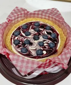 ชีสพายบลูเบอรี่สด พร้อมซอสบลูเบอรี่และครัสต์กรอบ เสิร์ฟบนจานสีดำ สร้างความน่ารับประทานและดึงดูดสายตา.