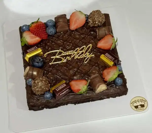 เค้กวันเกิดช็อกโกแลตตกแต่งด้วยผลไม้สดและช็อกโกแลตแท่ง พร้อมคำว่า "Birthday.