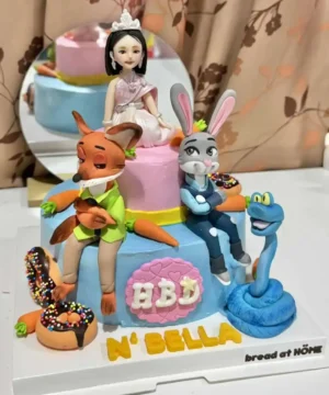 แป้งขนมปังตกแต่งเค้กวันเกิดตัวการ์ตูน นางเงือก ดอกไม้ และตัวละครจากการ์ตูน พร้อมคำว่า N'BELLA และ AID ทำเองที่บ้าน ขนมปังที่เน้นความน่ารักและสร้างสรรค์ในงานเลี้ยงเด็ก.