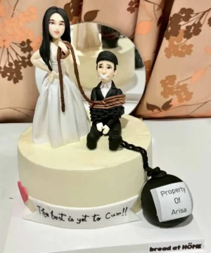 เค้กฟองดองน้ำตาลปั้น 3 มิติ แสดงภาพเค้กสุดหรูที่มีการออกแบบสร้างสรรค์ด้วยน้ำตาลปั้น พร้อมตัวละครและลูกบอลคำพูด.