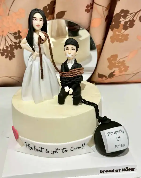 เค้กฟองดองน้ำตาลปั้น 3 มิติ แสดงภาพเค้กสุดหรูที่มีการออกแบบสร้างสรรค์ด้วยน้ำตาลปั้น พร้อมตัวละครและลูกบอลคำพูด.