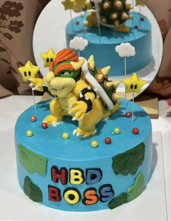 เค้กฟองดองน้ำตาลปั้น 3 มิติ สวยงามและหรูหราพร้อมตัวการ์ตูนมาริโอ้สุดน่ารักบนเค้กสีฟ้า สำหรับงานฉลองวันเกิดหรือโอกาสพิเศษที่ต้องการความสร้างสรรค์และความสนุกสนาน.