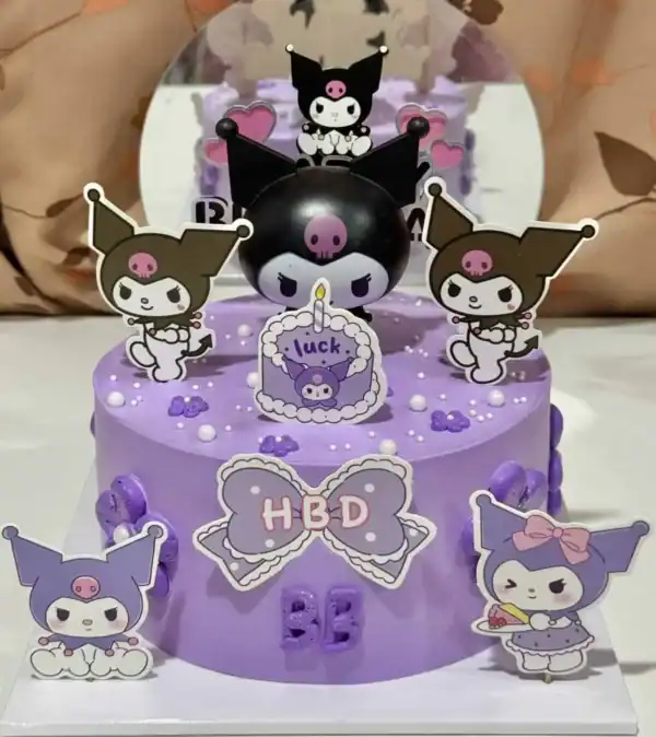 เค้กคุโรมิสีม่วงสดใสพร้อมตัวละครคุโรมิและดีไซน์น่ารัก เหมาะสำหรับงานฉลองและเป็นของขวัญสุดพิเศษสำหรับแฟนซานริโอ้.