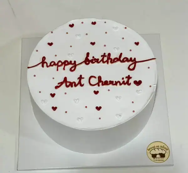 เค้กวันเกิดสีขาวตกแต่งด้วยหัวใจสีแดงและขาว พร้อมข้อความ 'happy birthday Ant Chanut' สำหรับโอกาสพิเศษ.