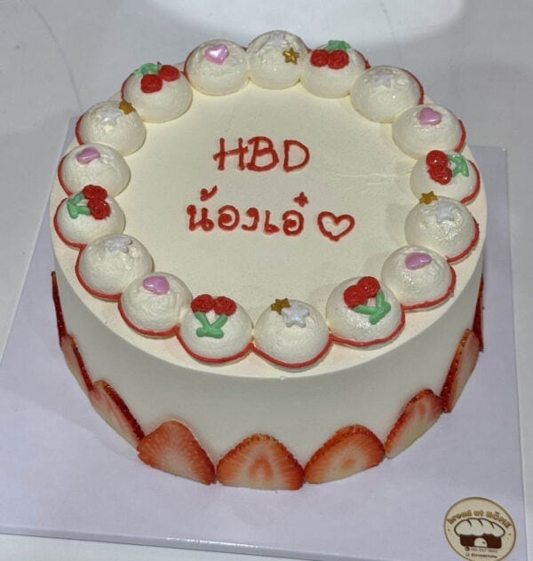 เค้กวันเกิดสีขาวตกแต่งด้วยผลไม้และครีมสด พร้อมข้อความ HBD น้องเอ๋.