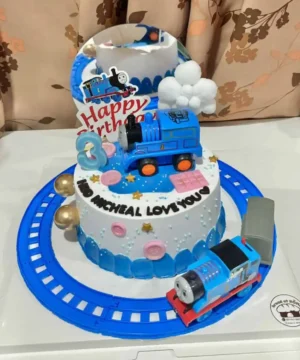 โมเดลเค้กวันเกิดทรงรถไฟสีน้ำเงินพร้อมของตกแต่งธีมการ์ตูนสำหรับเด็กในราคาเบรดแอทโฮม.