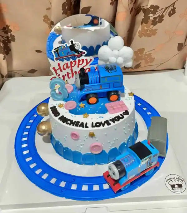 โมเดลเค้กวันเกิดทรงรถไฟสีน้ำเงินพร้อมของตกแต่งธีมการ์ตูนสำหรับเด็กในราคาเบรดแอทโฮม.