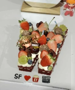 เค้กตัวอักษรวันเกิดทำจากผลไม้สดและครีมเนียนนุ่ม ตกแต่งด้วยผลไม้หลากสีและช็อกโกแลต สร้างความประทับใจในโอกาสพิเศษและเป็นไอเดียเค้กวันเกิดที่น่ารักและสร้างสรรค์.