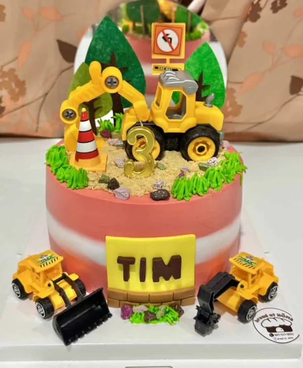 เค้กสุดน่ารักตกแต่งด้วยรถแม็คโครสีเหลืองและอุปกรณ์ก่อสร้าง เหมาะสำหรับเด็กอายุ 3 ขวบที่ชื่นชอบเครื่องมือก่อสร้างและของเล่นรถยนต์.